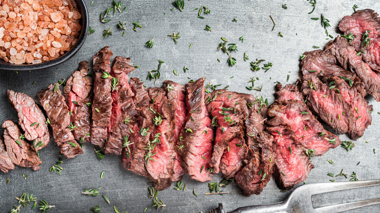 cooked and sliced skirt steak on a stone background
