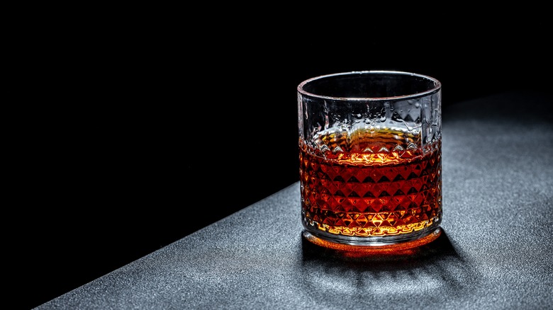 Whiskey in rocks glass on grey counter