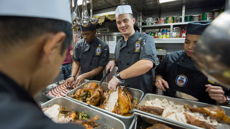 Culinary specialists serve up dinner to sailors.
