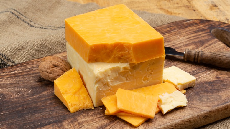 Blocks of white and orange cheddar cheese