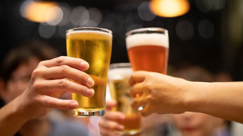 Two people cheers with pints of beer