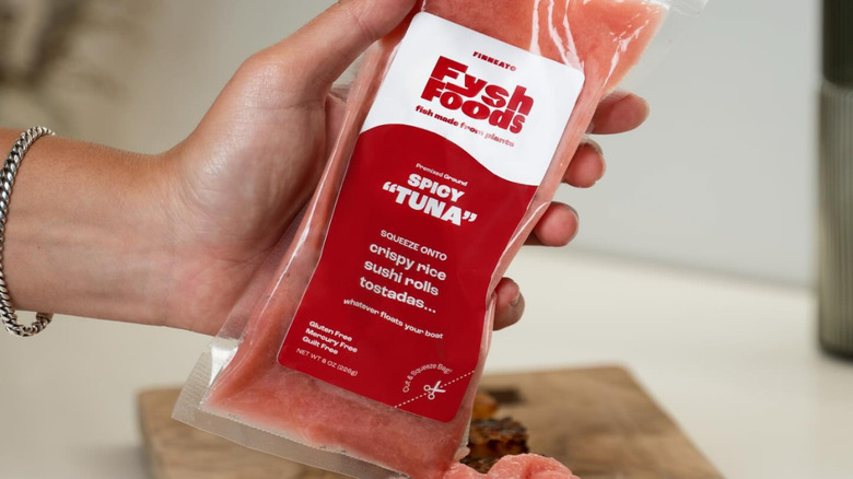 A hand holding a package of Finneato Fysh Foods spicy "tuna"