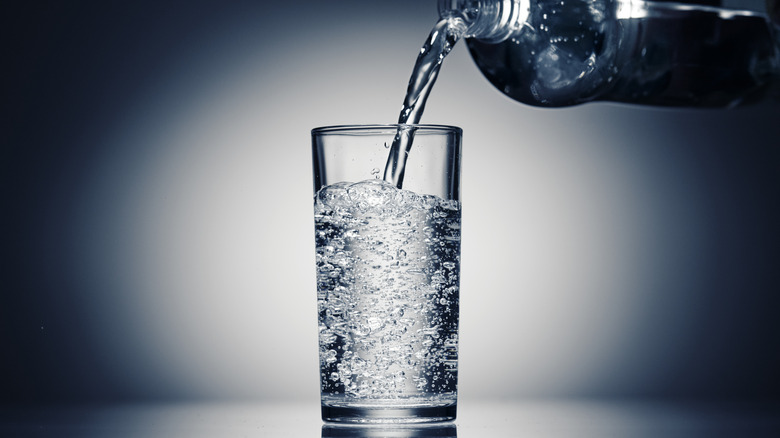 Pouring sparkling water into glass