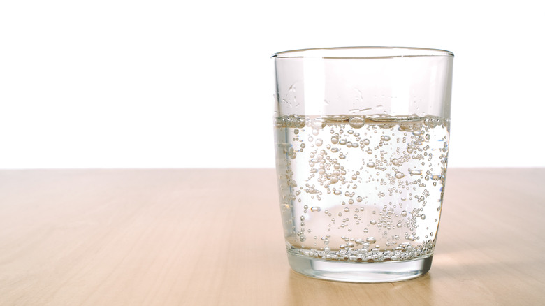 Glass of sparkling water on wooden table