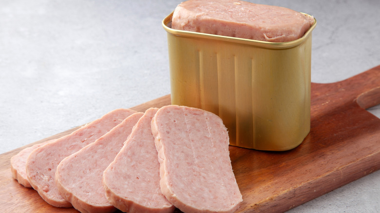 Slices of canned spam on wooden cutting board