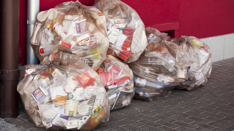 Bags of restaurant trash sit outside a McDonald's location.