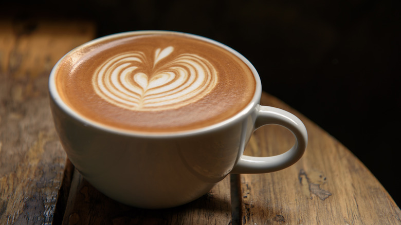 Breve coffee in white cup on wooden table