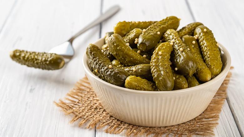 Bowl of cornichons, burlap, fork