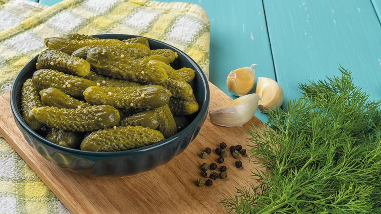 Bowl of cornichons with peppercorn, garlic, dill