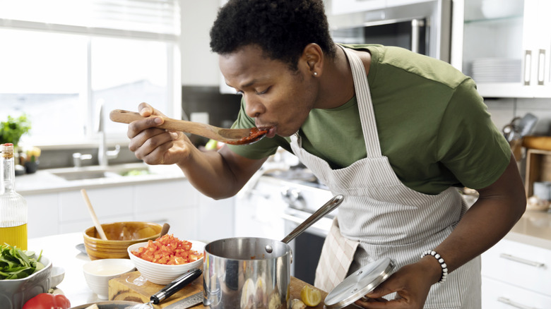 A home cook tastes the tomato sauce