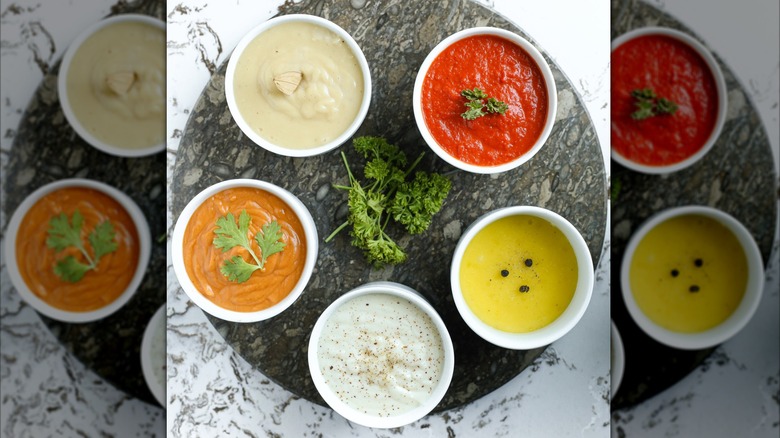 bowls of the five mother sauces rest on a stone lazy susan