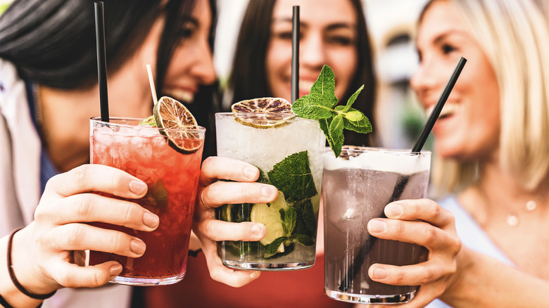 Three people cheers with different coctails