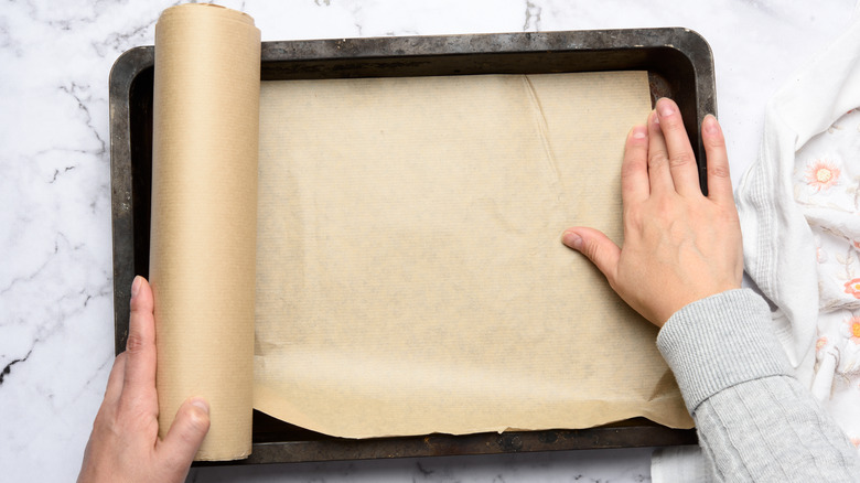 adding parchment to a jelly roll pan