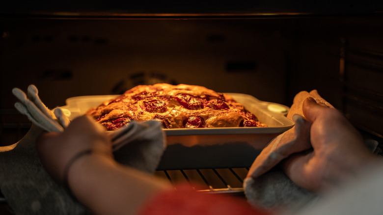 person taking cake out of oven