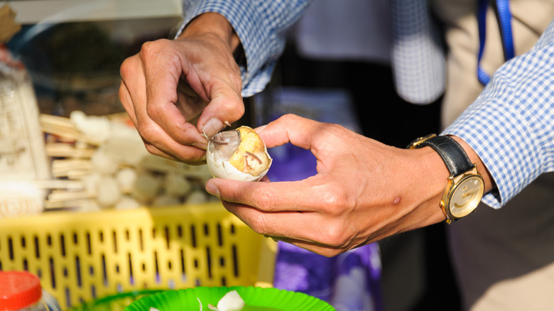 Person peeling balut