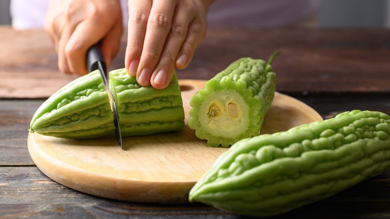 Cutting bitter melon with knife
