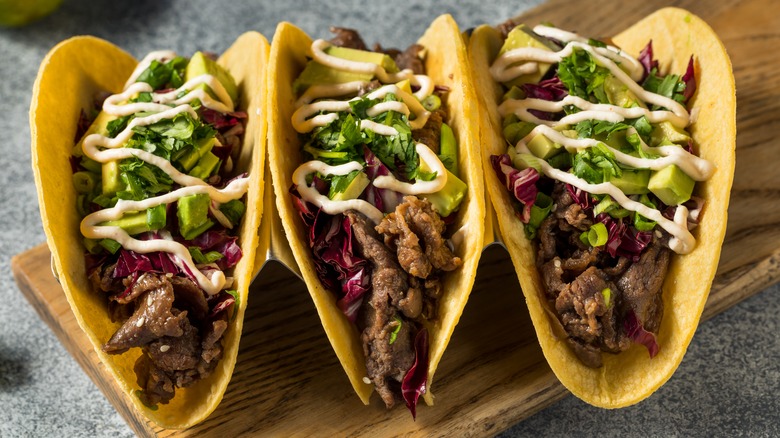 korean beef tacos topped with avocado and cilantro