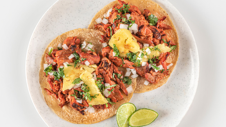 tacos al pastor with lime wedges