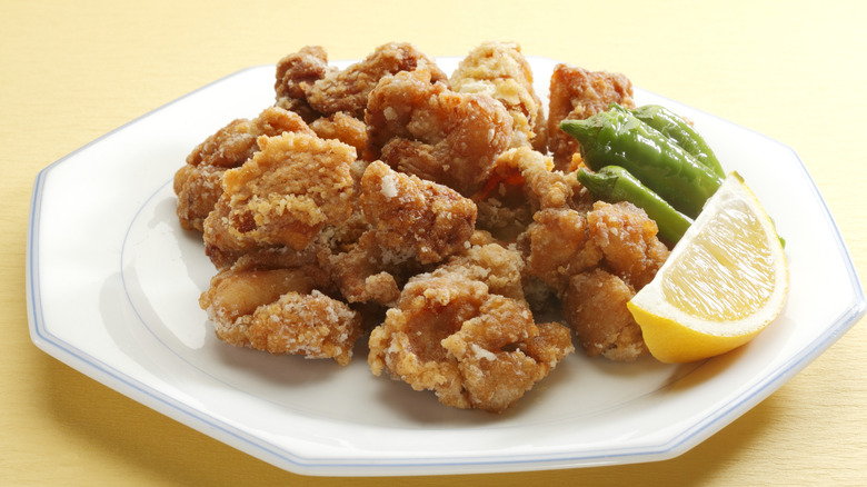 Japanese fried chicken, known as karaage, served on a dish with a lemon wedge and okra