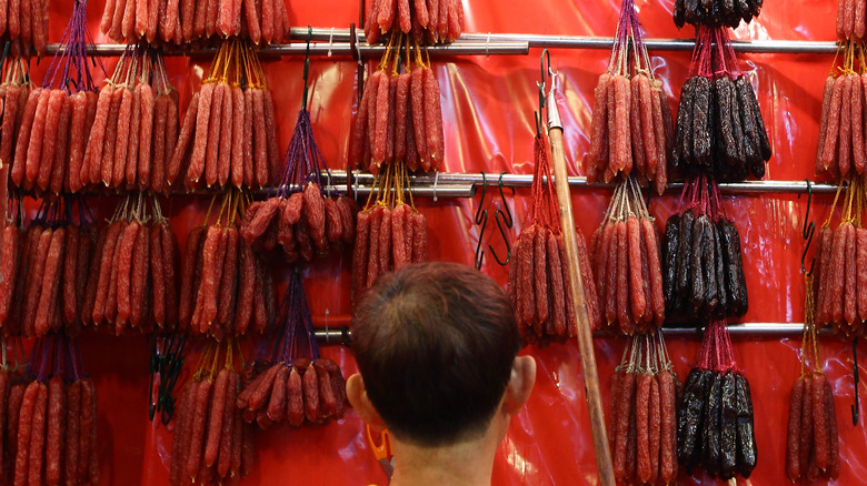 Man standing in front of display of lap cheong