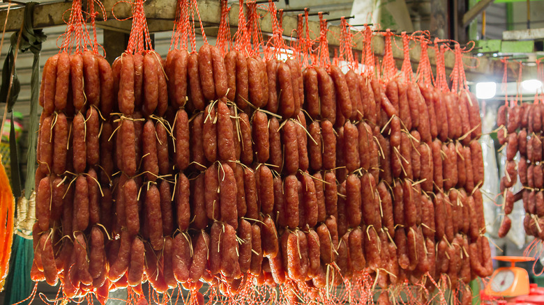 Strings of lap cheong links hanging in shop