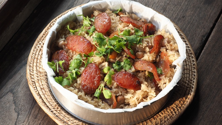 Rice topped with lap cheong slices and herbs