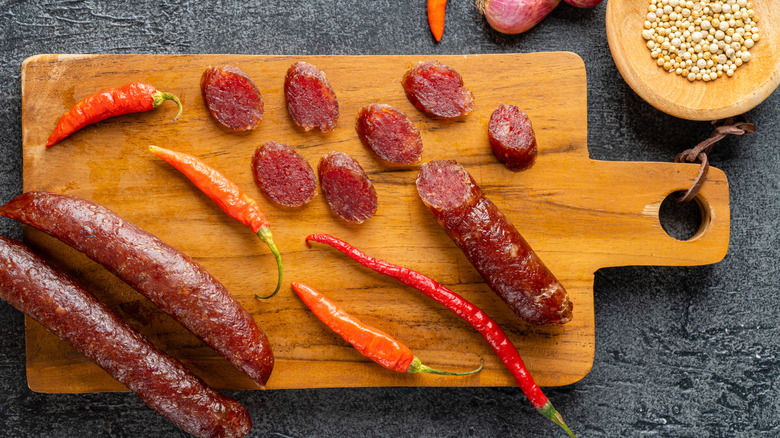 Lap cheong on cutting board with chiles