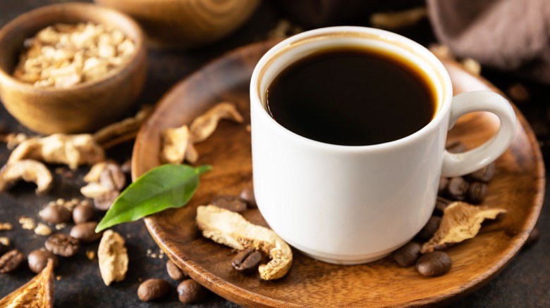 mushroom coffee in white mug with fresh mushrooms
