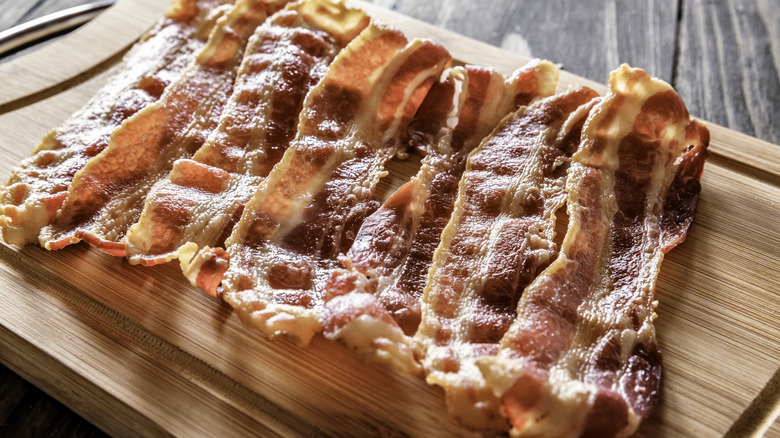 cooked bacon on cutting board