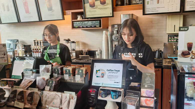Two Starbucks workers at the counter