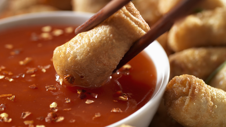 egg rolls dipped into sweet and sour sauce