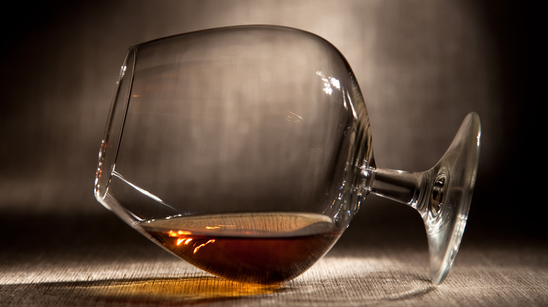 Brandy snifter on side with brandy in bottom