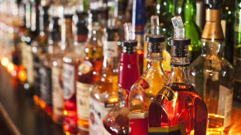 Many bottles of alcohol gleam on shelves