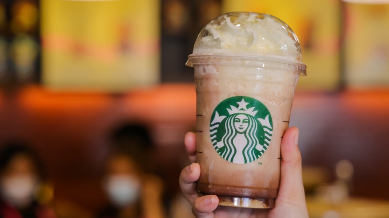 Hand holding up a Starbucks Frappuccino