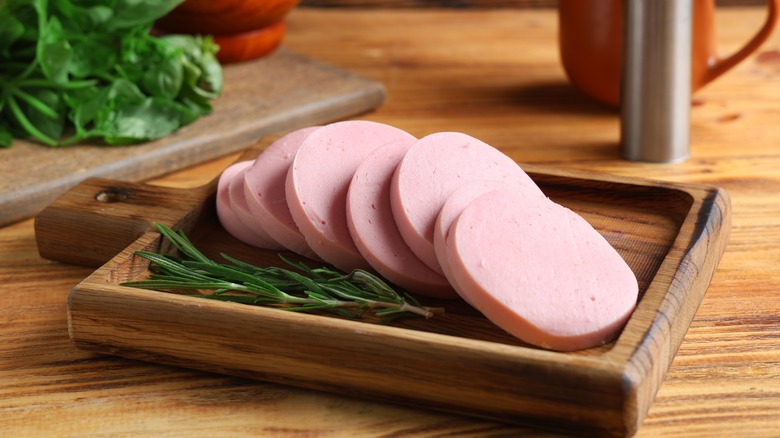 Thick slices of bologna meat on a board