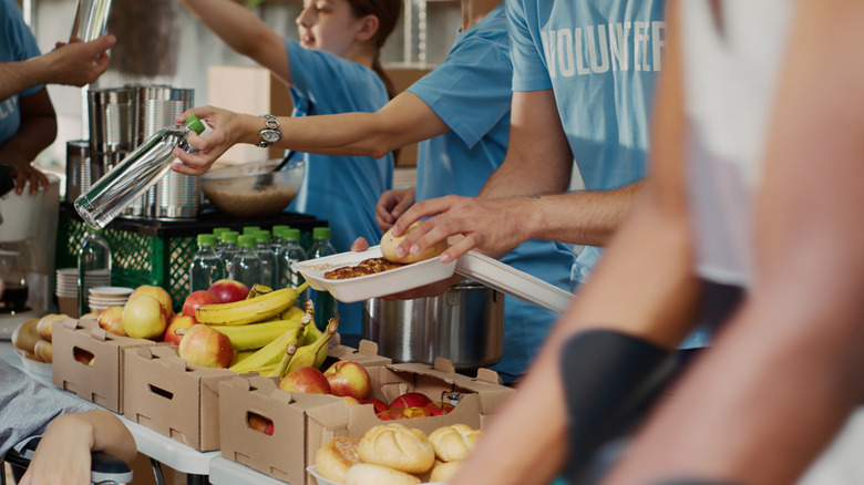 Volunteers hand out produce and other grocery goods at a food pantry.