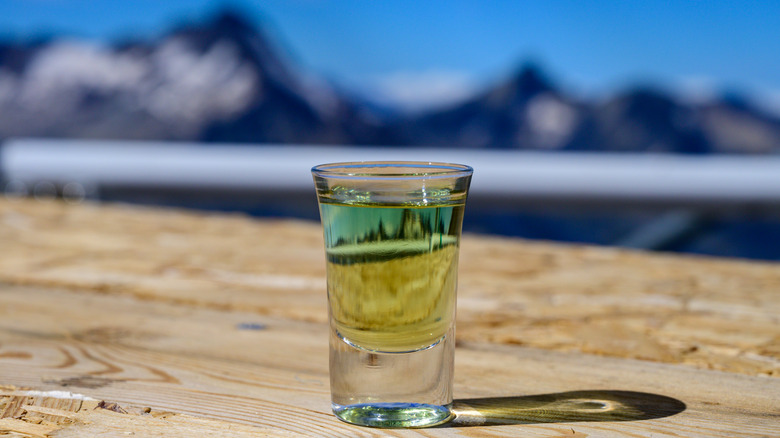 Alpine liqueur shot with mountains in background