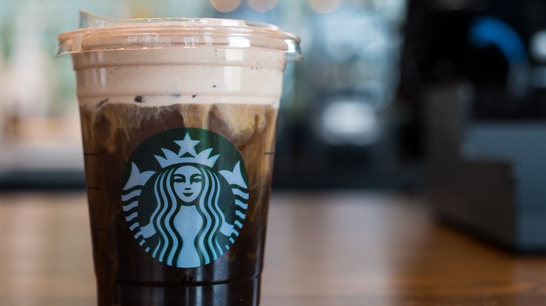 Starbucks shaken espresso topped with cold foam on wood table