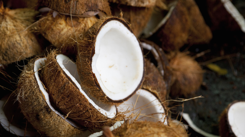 Opened coconuts on a dark surface