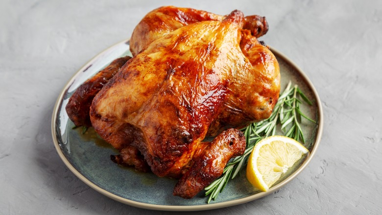 rotisserie chicken on plate with herbs