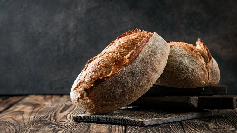 Crusty loaves of bread on wooden board