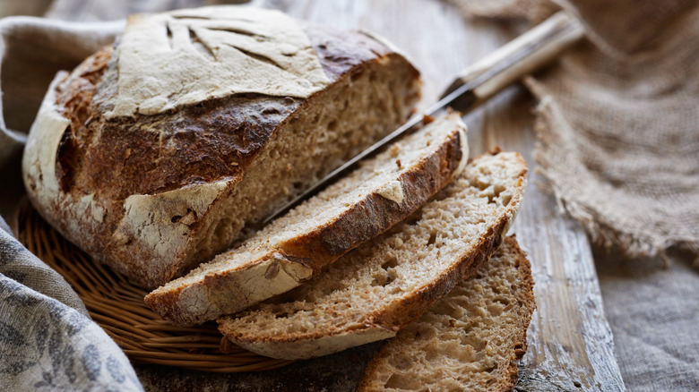 Rustic loaf of bread sliced with knife 