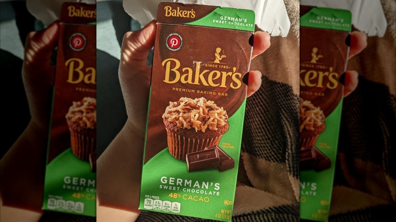 A hand holds a bar of Baker's German's sweet chocolate.