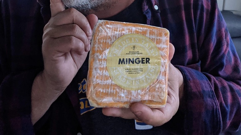 Hands holding a block of the Minger cheese