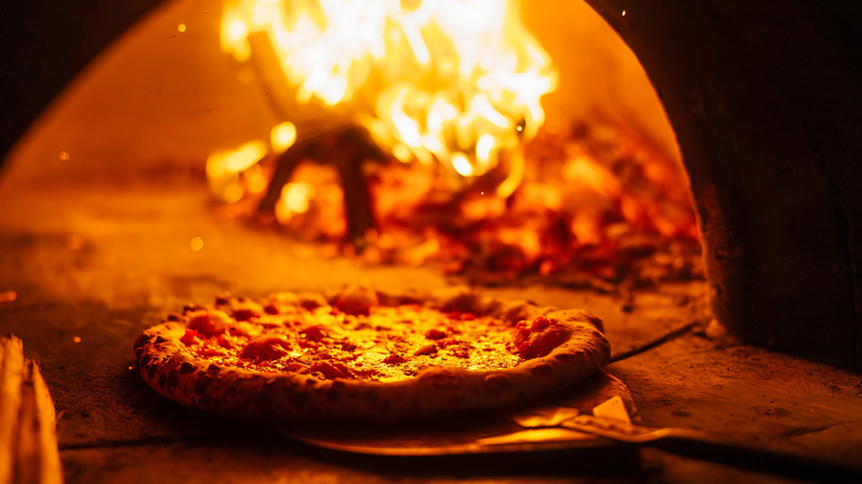 Pizza baking in a flaming oven
