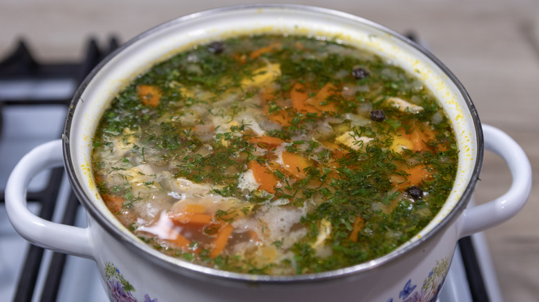 Soup sits in a big pot on a stove