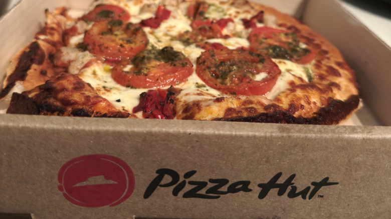 A Pizza Hut margherita pizza inside a branded pizza box.