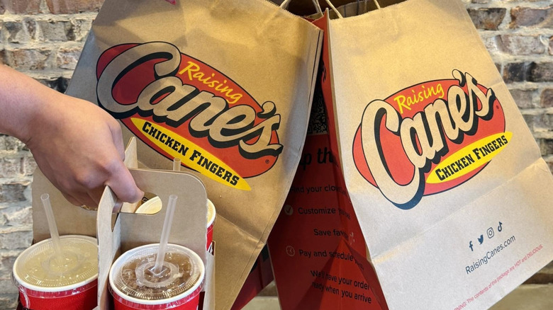 Bags of Raising Cane's food and drinks.