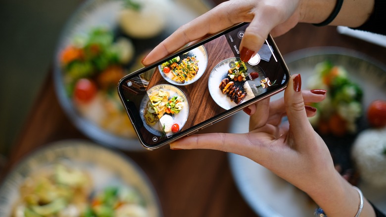 Woman taking photo of her food