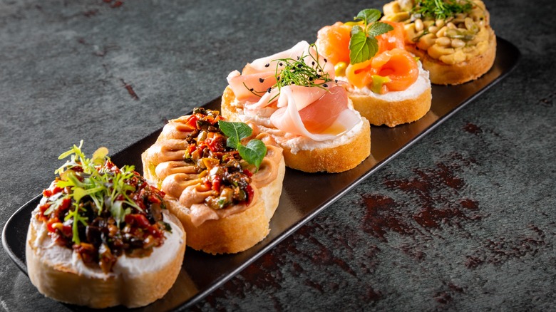 Various bruschettas on black plate